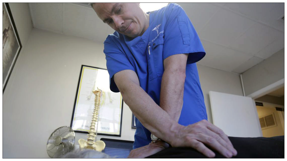 Dr. Kevin Reiseck works with a patient at his South Miami chiropractic clinic, the Miami Spine Center.
